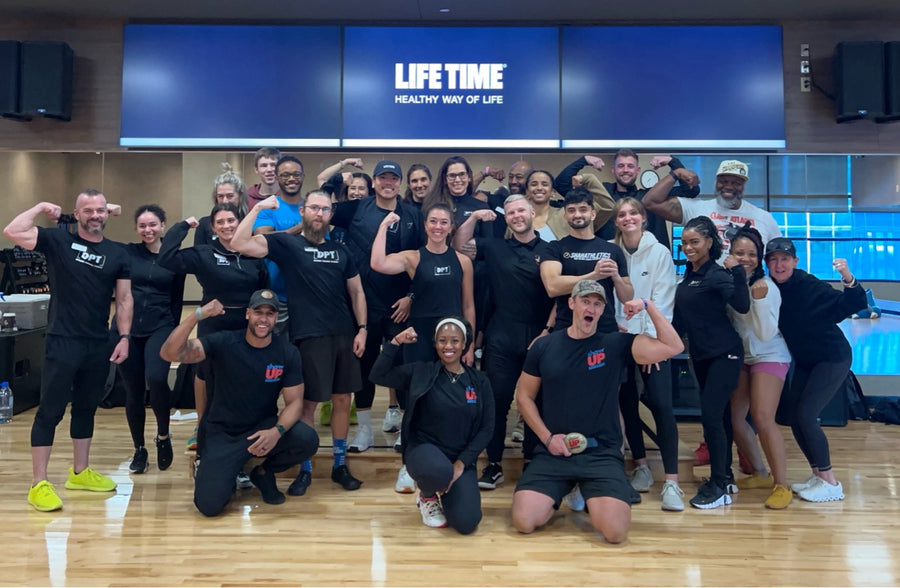 Show Up Fitness trainees posing together in a Life Time studio