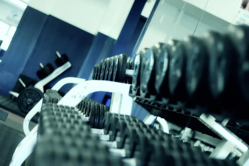 Close-up of a dumbbell rack in cool blue light