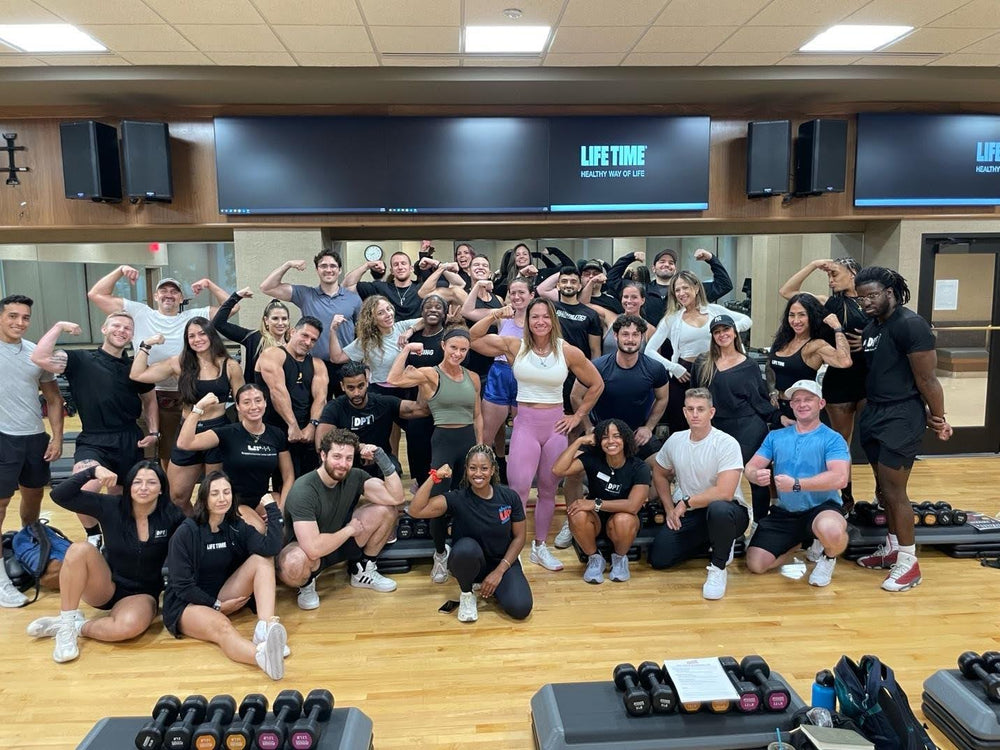 Show Up Fitness trainees flexing together in a Life Time gym studio